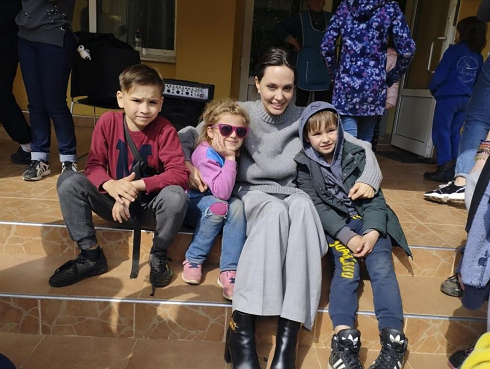 In this image provided by the Lviv city hall Angelina Jolie, Hollywood movie star and UNHCR goodwill ambassador, poses for photo with kids in Lviv, Ukraine, Saturday, Apr. 30, 2022. Ms Jolie was in Ukraine to meet the children affected by the war and visited hospitals and NGOs helping the injured and displaced. (Maksym Kozutsky/Lviv City Hall via AP)